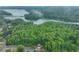 Aerial view showcases a home's wooded privacy near a lake and waterfront community at 6225 Leeward Tide Ct, Cumming, GA 30041