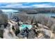Aerial view showcases the home's private pool and lake view beyond at 6225 Leeward Tide Ct, Cumming, GA 30041