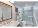 Bathroom featuring a wood framed mirror above a marbled vanity and a glass-enclosed shower at 6225 Leeward Tide Ct, Cumming, GA 30041