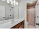 Bathroom with white stone counter, generous mirror, and shower with curtained entry at 6225 Leeward Tide Ct, Cumming, GA 30041