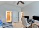Bedroom with a ceiling fan, carpet flooring, desk with dual monitors, and a view to hall and bathroom at 6225 Leeward Tide Ct, Cumming, GA 30041