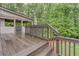 Wooden deck steps leading to a beautiful backyard surrounded by mature trees and lush landscaping at 6225 Leeward Tide Ct, Cumming, GA 30041