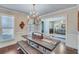 An inviting dining area shows a wooden table with bench seating and view into the home's living room at 6225 Leeward Tide Ct, Cumming, GA 30041
