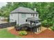 Rear exterior view showcasing a multi-level deck, screened porch, and wooded lot at 6225 Leeward Tide Ct, Cumming, GA 30041