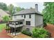 Rear exterior view showcasing a deck, covered porch, patio, and lush landscaping at 6225 Leeward Tide Ct, Cumming, GA 30041