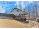 Exterior back of home with a spacious yard, deck, and wooded area at 6225 Leeward Tide Ct, Cumming, GA 30041
