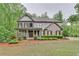 Charming two-story home featuring manicured landscaping, a covered porch, and a mix of brick and siding at 6225 Leeward Tide Ct, Cumming, GA 30041