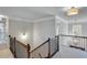 Bright hallway with elegant wood and iron staircase, crown molding, and contemporary light fixtures at 6225 Leeward Tide Ct, Cumming, GA 30041
