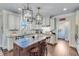 Elegant kitchen features white cabinetry, granite countertops, a large island and modern pendant lighting at 6225 Leeward Tide Ct, Cumming, GA 30041