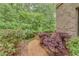 Landscaped side yard featuring a gravel path, mature plantings, and wooded view at 6225 Leeward Tide Ct, Cumming, GA 30041