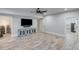 Spacious living room with wood look flooring, a large TV, a rustic console and a wine cooler at 6225 Leeward Tide Ct, Cumming, GA 30041