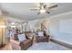 Inviting living room featuring hardwood floors, a ceiling fan, two brown leather chairs and a white patterned rug at 6225 Leeward Tide Ct, Cumming, GA 30041
