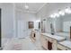 Light filled main bathroom features double vanities, granite counters, soaking tub, and tiled floors at 6225 Leeward Tide Ct, Cumming, GA 30041