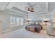 Spacious main bedroom featuring a trey ceiling with a fan and bright natural light at 6225 Leeward Tide Ct, Cumming, GA 30041