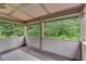 Covered porch with neutral panelling, a patterned rug, and views of lush trees at 6225 Leeward Tide Ct, Cumming, GA 30041