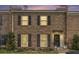 Charming brick townhome with black shutters, a black door, and manicured landscaping at 8 Kings Ne Walk, Atlanta, GA 30307