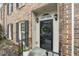 Inviting front entry with a black door, wreath, and stone walkway at 8 Kings Walk Ne, Atlanta, GA 30307