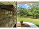 Outdoor stone fireplace feature, lush green grass, mature trees, and outdoor living space at 878 Forrester Cemetery Rd, Covington, GA 30014