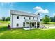 The rear exterior of this two-story home has a covered patio with a stone fireplace and a vast lawn at 878 Forrester Cemetery Rd, Covington, GA 30014