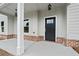 A welcoming front porch has classic columns, brick accents, and an elegant front door at 878 Forrester Cemetery Rd, Covington, GA 30014