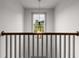 Upstairs hallway features neutral carpet, light gray color palette, and an ornamental chandelier at 878 Forrester Cemetery Rd, Covington, GA 30014