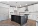 Modern kitchen with island, white cabinets, and hardwood floors at 878 Forrester Cemetery Rd, Covington, GA 30014