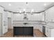 Open kitchen boasts white cabinets, a dark island, and modern stainless steel appliances at 878 Forrester Cemetery Rd, Covington, GA 30014