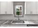 Close up of kitchen sink with quartz countertops, stainless steel appliances and subway tile backsplash at 878 Forrester Cemetery Rd, Covington, GA 30014