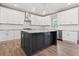 Stylish kitchen with stainless steel appliances, dark island and hardwood floors at 878 Forrester Cemetery Rd, Covington, GA 30014