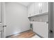 Functional laundry area with wooden floors, cabinets and modern white walls at 878 Forrester Cemetery Rd, Covington, GA 30014