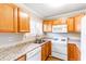 Well-lit kitchen with stainless steel sink, modern countertops, and white appliances at 1807 Ashborough Cir # G, Marietta, GA 30067