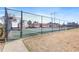 View of the community tennis court ready for a friendly match, surrounded by green grass and a secure fence at 1807 Ashborough Cir # G, Marietta, GA 30067