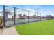 View of the community tennis court ready for a friendly match, surrounded by green grass and a secure fence at 1807 Ashborough Cir # G, Marietta, GA 30067