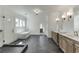 A luxurious bathroom featuring a freestanding tub, glass shower, and double vanities with stone countertops at 2427 Wolf Meadow Ln, Buford, GA 30518