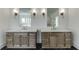 A modern bathroom featuring double sinks with stone countertops and dark-tiled floors at 2427 Wolf Meadow Ln, Buford, GA 30518