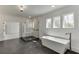 A bright bathroom featuring a glass shower, standalone tub, dark floors, and natural light at 2427 Wolf Meadow Ln, Buford, GA 30518
