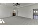 A large bedroom with neutral tones, a ceiling fan and an open doorway to the Primary bath at 2427 Wolf Meadow Ln, Buford, GA 30518
