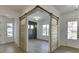 Stylish interior view featuring unique barn doors, light hardwood floors, and white trim accents at 2427 Wolf Meadow Ln, Buford, GA 30518