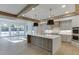 Open-concept kitchen with a large island, modern appliances, and wood beam accents, perfect for entertaining at 2427 Wolf Meadow Ln, Buford, GA 30518