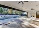 Covered patio with an outdoor fireplace, ceiling fans, stone flooring, and pool beyond at 2427 Wolf Meadow Ln, Buford, GA 30518