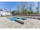 Backyard pool and hot tub is surrounded by an attractive stone patio and well-manicured landscaping at 2427 Wolf Meadow Ln, Buford, GA 30518