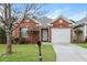 Charming one-story red brick home featuring a well-manicured front lawn and a one car garage at 621 Shadow Lake Dr, Lithonia, GA 30058