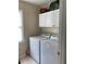 Well-lit laundry area featuring white cabinets above the washer and dryer at 1959 Firelight Ln, Buford, GA 30519