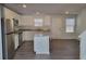 Modern kitchen with white cabinets, stainless appliances, granite counters, island, and grey floors at 140 Tye St, Stockbridge, GA 30281