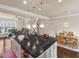 Open kitchen with granite island, pendant lights, and stainless steel appliances flowing into the dining area at 2659 Village Park Bnd, Duluth, GA 30096