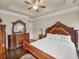 Elegant main bedroom with tray ceilings, a ceiling fan, and classic furnishings at 2659 Village Park Bnd, Duluth, GA 30096