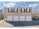 Four-car garage featuring four white doors and a utility door with black shutters at 1391 Old Coach Sw Rd, Marietta, GA 30008