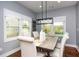 Elegant dining room features a modern light fixture, neutral decor, and sunlit windows for a welcoming atmosphere at 221 Cobb St, Palmetto, GA 30268
