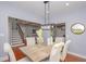 Stylish dining room featuring a modern light fixture, neutral tones, and view of a staircase and living room at 221 Cobb St, Palmetto, GA 30268