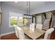 Bright dining room featuring a modern light fixture, wood table, and natural light from a large window at 221 Cobb St, Palmetto, GA 30268